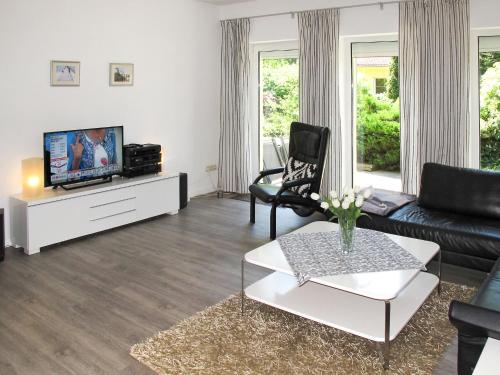 a living room with a couch and a tv at Holiday Home Am Walde by Interhome in Lubmin