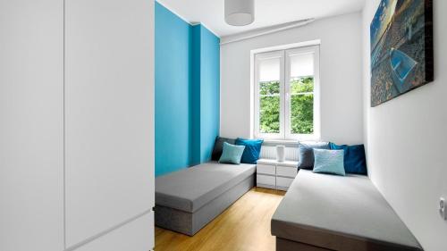 salon z niebieskimi ścianami i kanapą w obiekcie Baltic Capital - BillBerry Apartments w Gdańsku