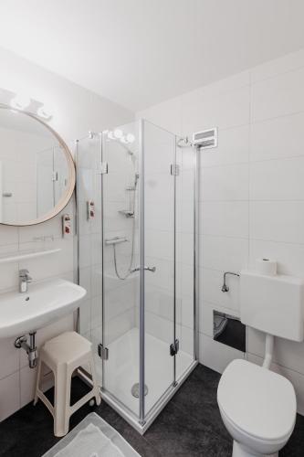 a bathroom with a shower and a sink and a toilet at Hotel Mörbischerhof in Mörbisch am See