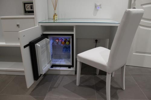 a white chair sitting under a table with a refrigerator at Anfitrite B&B Tropea in Tropea