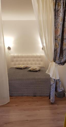 a bedroom with a bed with a curtain and a window at Palanga-Smilgu. g. in Palanga