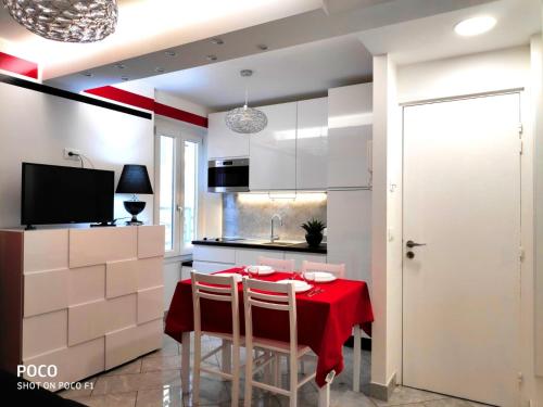 une cuisine avec une table et un chiffon rouge dans l'établissement Logement de Catherine, à Nice