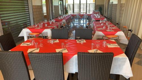 een lange eetkamer met rode tafels en stoelen bij Stanza vacanza lo stadio in Sibari