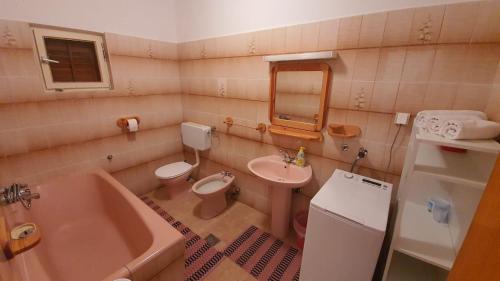 a bathroom with a sink and a toilet and a tub at Apartment Majda in Rab