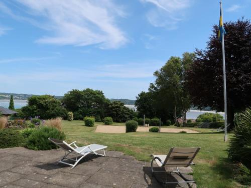 2 chaises assises sur une terrasse avec drapeau dans l'établissement Holiday Home Ker Svea by Interhome, à Plestin-les-Grèves