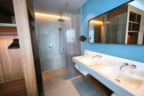 a bathroom with two sinks and a shower at Van der Valk Hotel Amsterdam Zuidas -Rai in Amsterdam