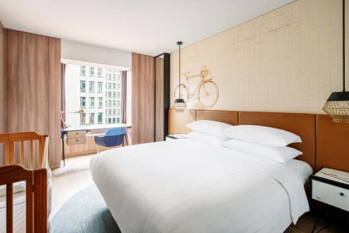 a bedroom with a white bed with a bike on the wall at JEN Singapore Tanglin by Shangri-La in Singapore