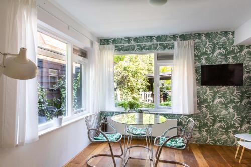 a dining room with a table and chairs and windows at Villa 1913 in Bergen