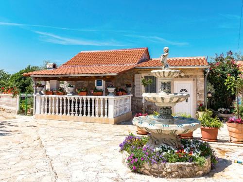 a house with a fountain in front of a building at Holiday Home Glavica by Interhome in Medaki