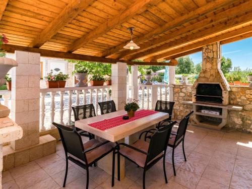 a patio with a table and chairs and an outdoor oven at Holiday Home Glavica by Interhome in Medaki