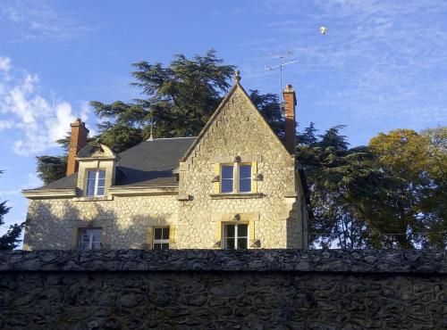 a house on top of a stone wall at Le Clos Des Ormeaux in Vineuil