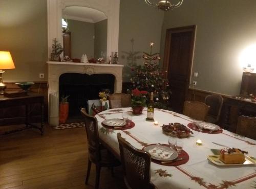 a dining room with a table and a christmas tree at Le Clos Des Ormeaux in Vineuil