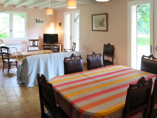 a room with a table with chairs and a living room at Holiday Home Cherte by Interhome in Uza