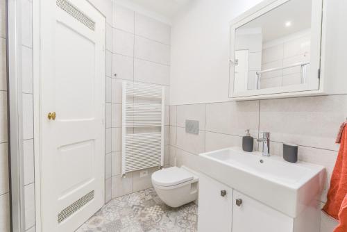 een witte badkamer met een toilet en een wastafel bij Brand New Apartment next to Old Town Square in Praag