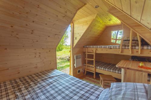 a bedroom in a log cabin with two bunk beds at Kargaja Kuke Saun & Kämping in Padakõrve