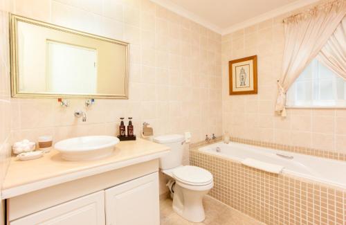 a bathroom with a toilet and a sink and a tub at Shandon Lodge Guest House & Spa in Nelspruit