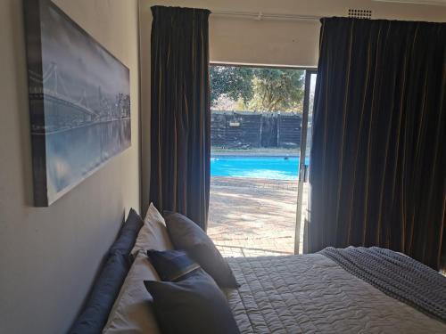 a bedroom with a bed and a sliding glass door at The Yellow Butterfly in Vereeniging