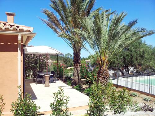 a patio with two palm trees and a swimming pool at Holiday Home Primavera - GAL200 by Interhome in Galeria