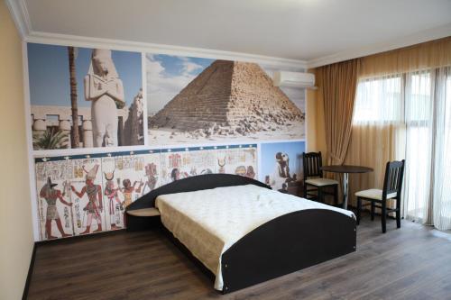 a bedroom with a wall mural of a pyramid at Meatsa Hotel in Kŭrdzhali