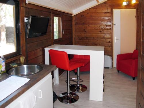 a kitchen with a sink and a counter with a red stool at Holiday Home Chalet 2 pers by Interhome in Calvi