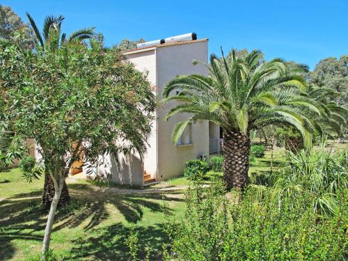 a house with two palm trees in front of it at Apartment Thalassa - CAL200 by Interhome in Calvi
