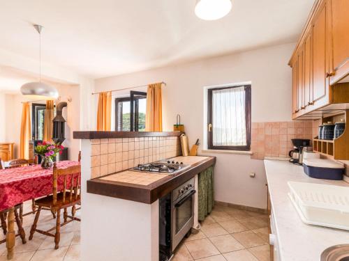 a kitchen with a stove top oven next to a table at Holiday Home Kušar by Interhome in Motovun