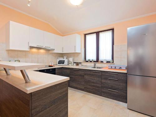 a kitchen with white cabinets and a stainless steel refrigerator at Apartment Paladin - MVN252 by Interhome in Motovun
