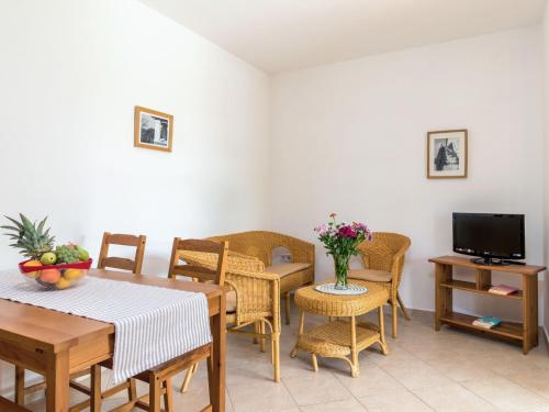 salon ze stołem, krzesłami i telewizorem w obiekcie Apartment Villa Sand-4 by Interhome w mieście Stifanići