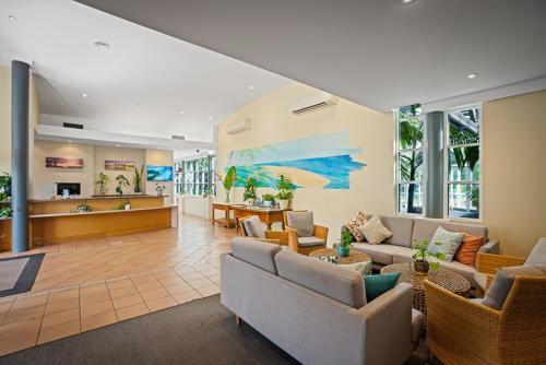 a large living room with couches and tables andwindows at Broadwater Resort in Busselton