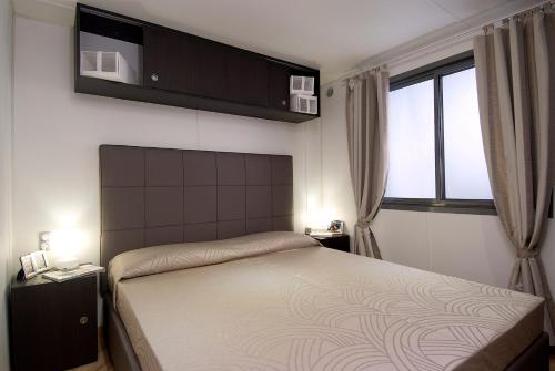 sypialnia z łóżkiem i oknem w obiekcie Casa mobile-Camping Bella Italia w mieście Peschiera del Garda