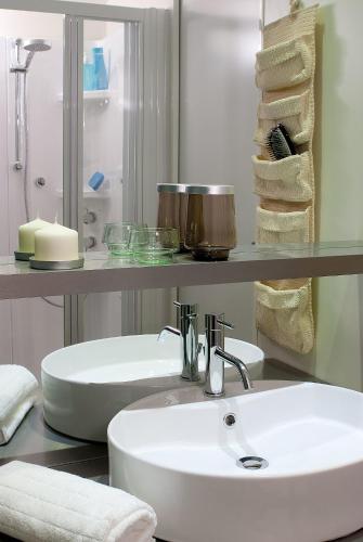 a bathroom with a white sink and a shelf with towels at Casa mobile-Camping Bella Italia in Peschiera del Garda