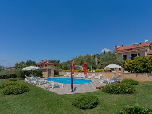 - une piscine avec des chaises et des parasols dans la cour dans l'établissement Apartment Jukić - KST136 by Interhome, à Kaštelir