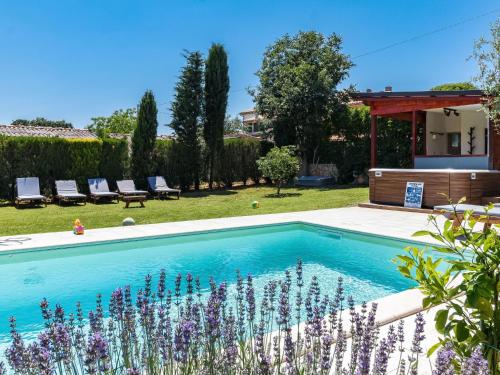 a swimming pool in a garden with purple flowers at Holiday Home Petar - KST253 by Interhome in Tar