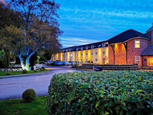 a building with a lot of bushes in front of it at Cottons Hotel and Spa in Knutsford