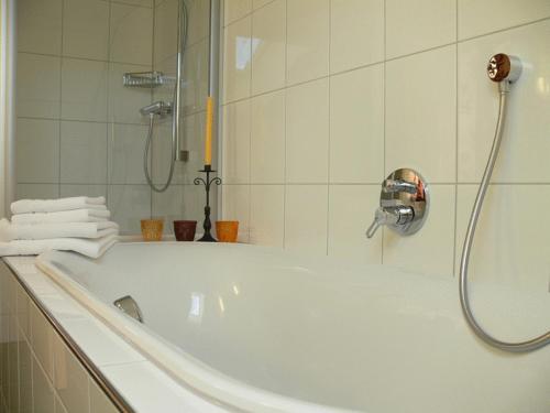Gasthaus Engel في بيزاو: حمام أبيض مع حوض استحمام ودش