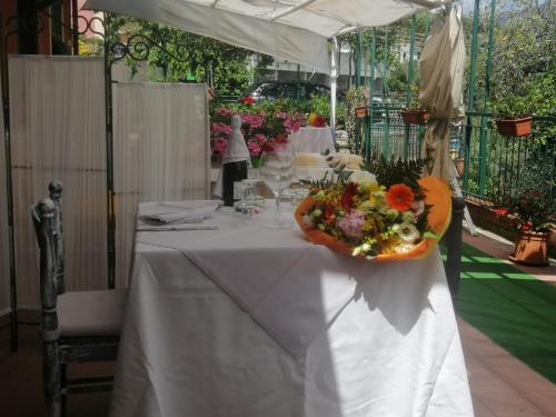 a table with a white table cloth and a bowl of flowers at Rooms and Breakfast da Carla in Sestri Levante