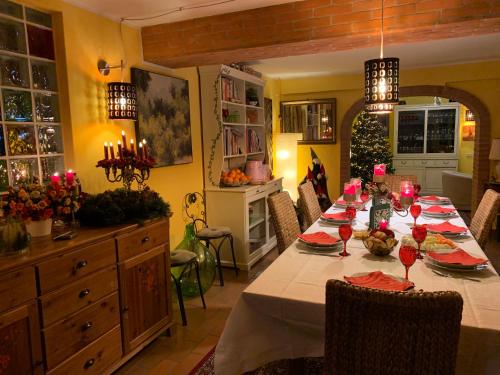 a dining room with a long table with red candles at Casa Serenella in Piazzola sul Brenta