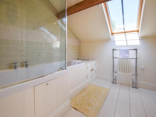 bagno con lavandino, vasca e finestra di Oldbury Barn a Cheltenham