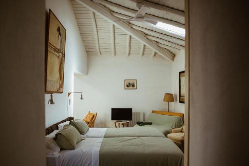 ein Schlafzimmer mit 2 Betten und einem TV in der Unterkunft Dehesa El Águila 