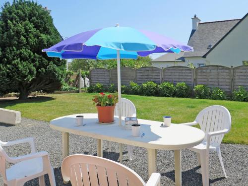 une table blanche avec un parasol bleu et des chaises dans l'établissement Holiday Home Ty Maï Pi by Interhome, à Lanros