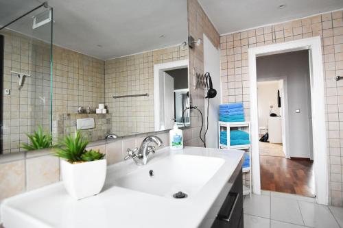 ein Badezimmer mit einem weißen Waschbecken und einem Spiegel in der Unterkunft Dorya am Ring in Köln