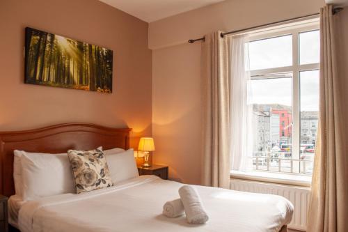 a bedroom with a bed and a window at Thirteen On The Green - Eyre Square in Galway