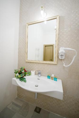 a bathroom with a white sink and a mirror at Grand Hotel Traian in Iaşi