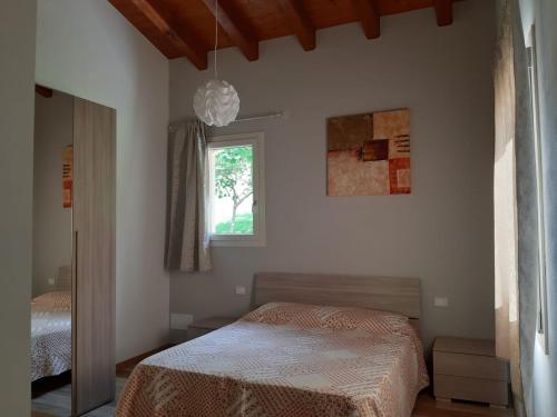 1 dormitorio con cama y ventana en B&B LE AGAVI, en Borso del Grappa