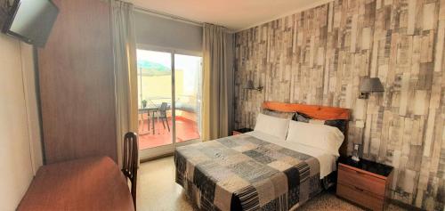 a bedroom with a bed and a window with a table at Marinada Cambrils in Cambrils