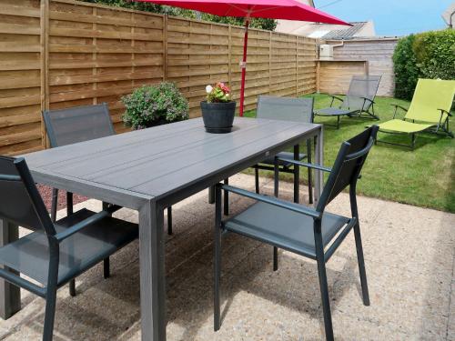 - une table de pique-nique avec des chaises et un parasol dans l'établissement Holiday Home Tal Ar Mor by Interhome, à Plounévez-Lochrist