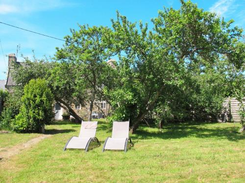 deux chaises blanches assises dans l'herbe sous un arbre dans l'établissement Holiday Home Ty Jos - CZN139 by Interhome, à Crozon
