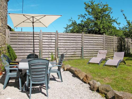 une terrasse avec une table, des chaises et un parasol dans l'établissement Holiday Home Ty Jos - CZN139 by Interhome, à Crozon