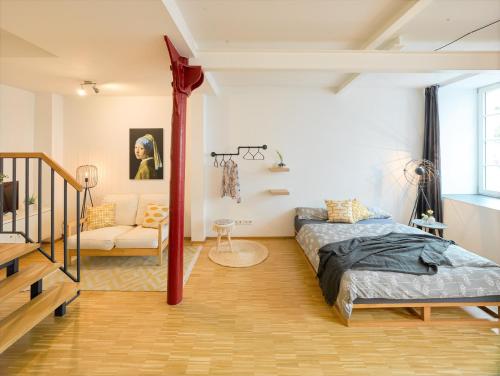 a bedroom with a bed and a couch in a room at ☆Design Apartment Zentral☆200m vom Marktplatz☆ruhige Altstadtlage☆ in Reutlingen