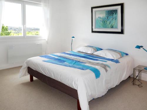 クロゾンにあるFerienhaus Crozon 134Sの白いベッドルーム(青と白の毛布付きのベッド1台付)